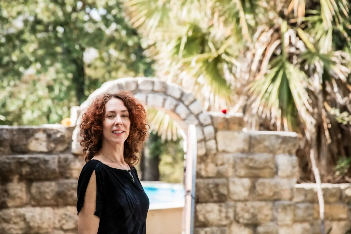 Maria with both palms open under the arch
