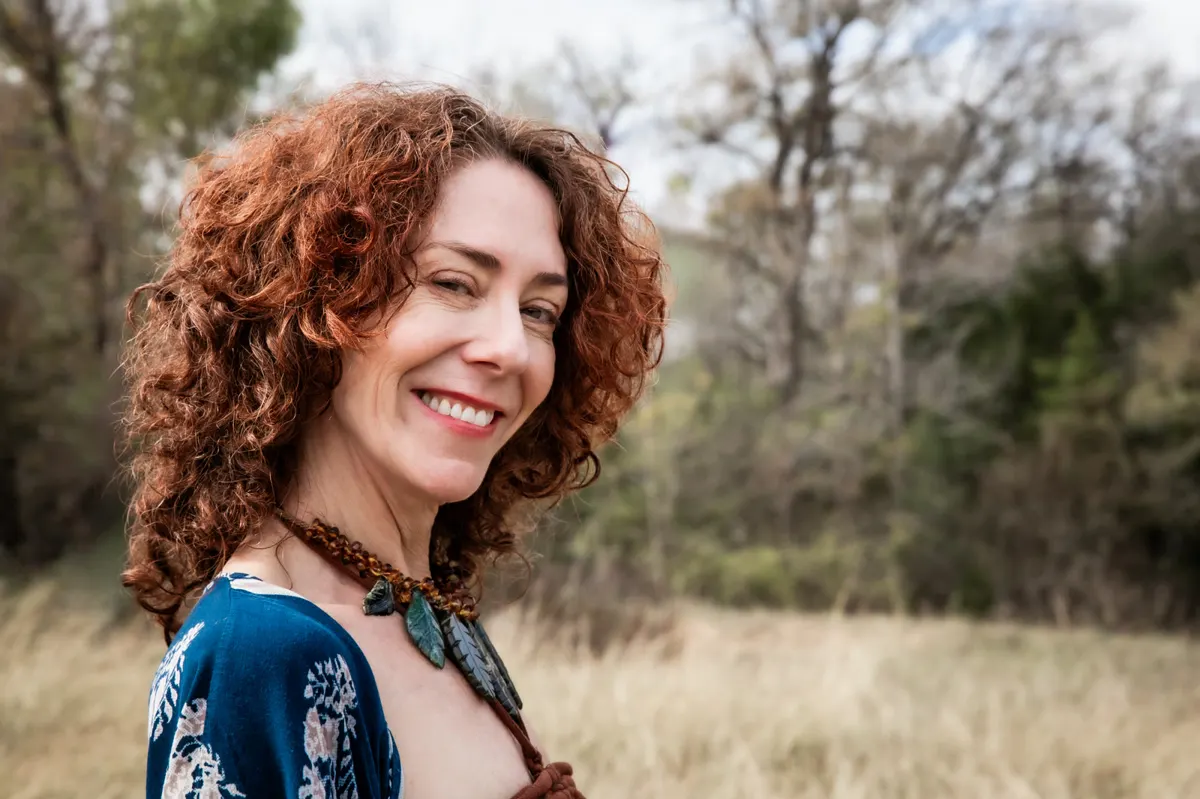 Maria smiling in a meadow